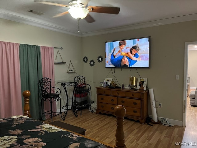 bedroom with ceiling fan, crown molding, and light hardwood / wood-style flooring