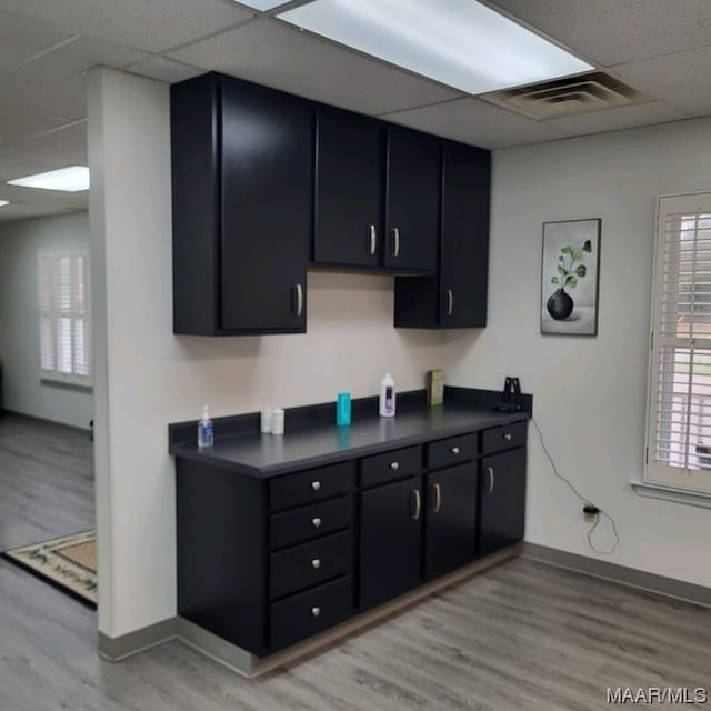 kitchen featuring light hardwood / wood-style flooring and a paneled ceiling