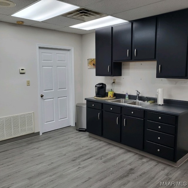 kitchen featuring light hardwood / wood-style floors, a drop ceiling, and sink