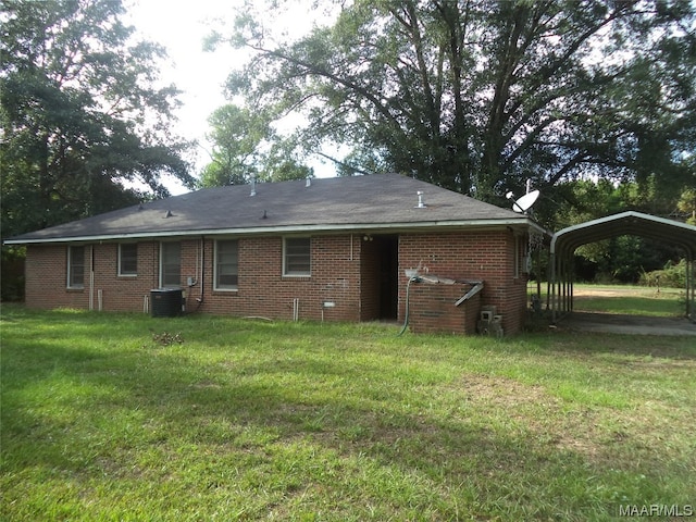 rear view of property with central air condition unit and a lawn