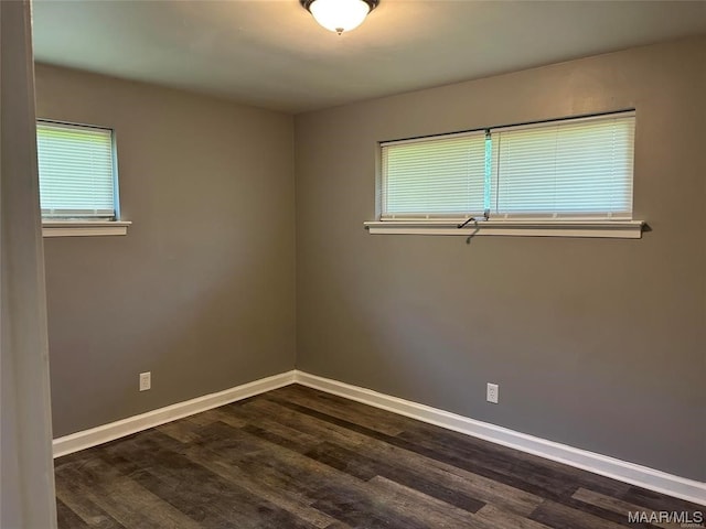 unfurnished room featuring a wealth of natural light and dark hardwood / wood-style floors