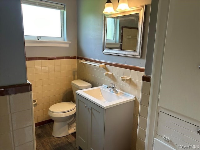 bathroom with vanity, backsplash, tile walls, wood-type flooring, and toilet