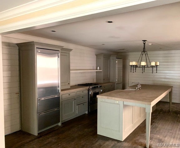 kitchen featuring dark hardwood / wood-style flooring, decorative light fixtures, a chandelier, gray cabinetry, and high end stainless steel range oven