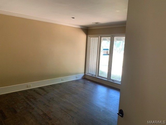 empty room featuring crown molding and dark hardwood / wood-style floors