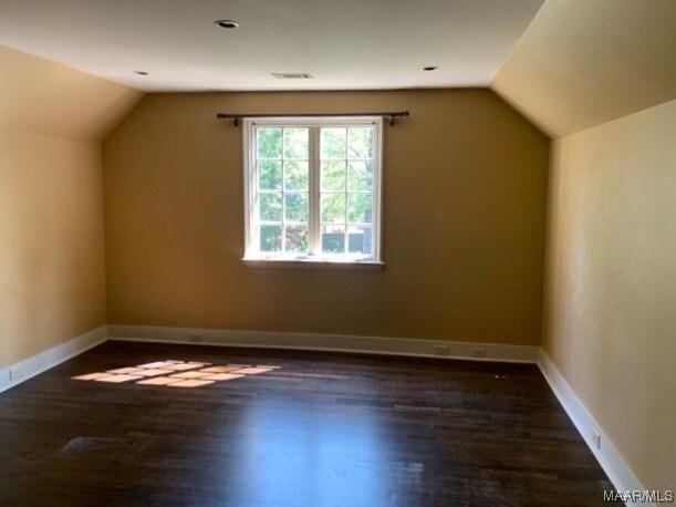 additional living space featuring lofted ceiling and dark hardwood / wood-style floors