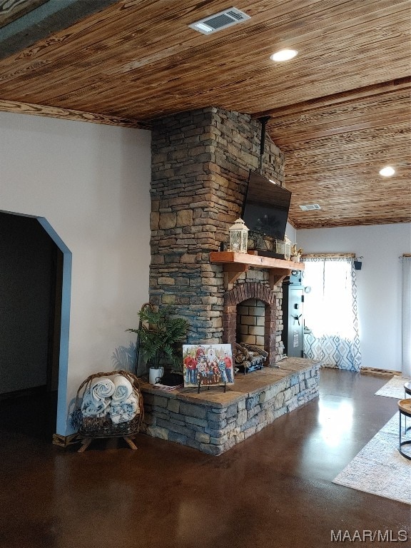 unfurnished living room with wooden ceiling and a stone fireplace