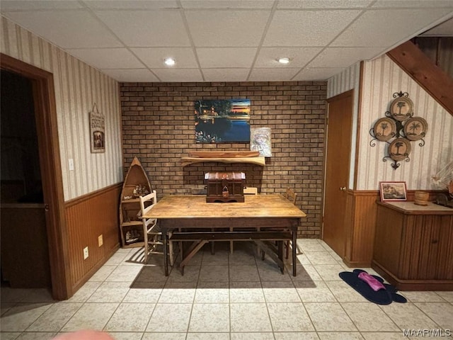 interior space featuring light tile patterned floors and a drop ceiling