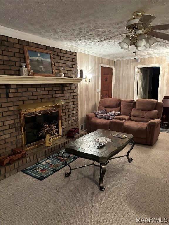 living room featuring carpet, a fireplace, ceiling fan, and a textured ceiling