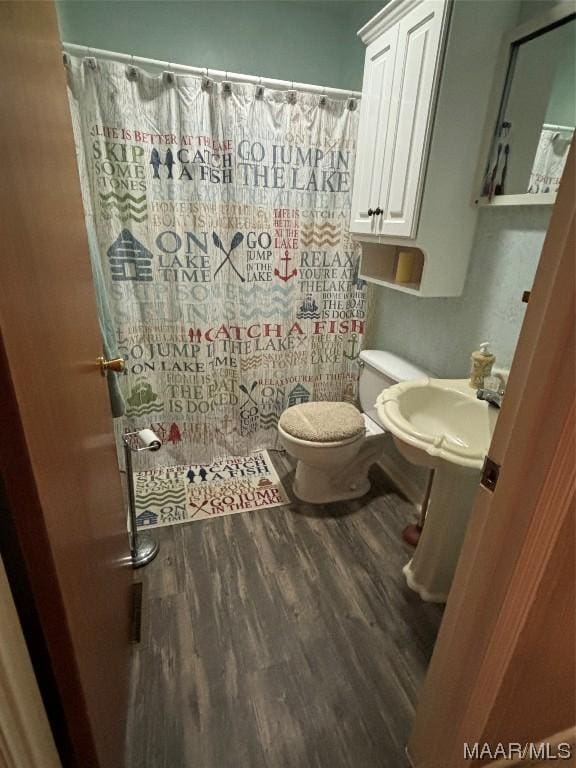 bathroom featuring wood-type flooring, sink, toilet, and walk in shower