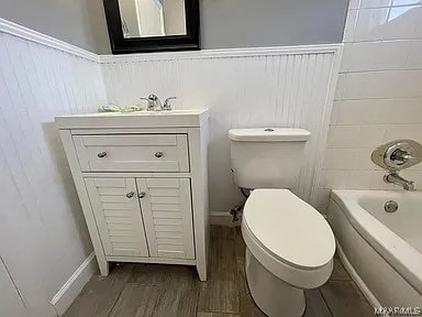 full bathroom featuring hardwood / wood-style flooring, vanity, toilet, and shower / washtub combination