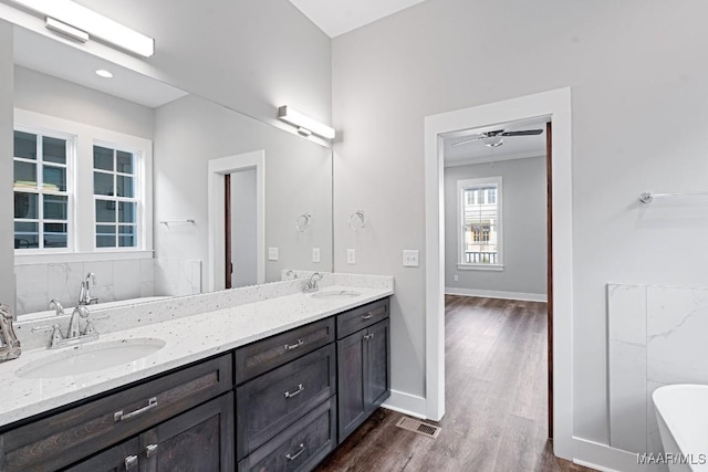 bathroom with vanity, wood-type flooring, and a bath