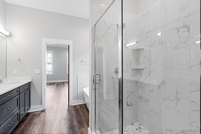 bathroom featuring plus walk in shower, hardwood / wood-style floors, and vanity