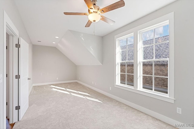 bonus room with vaulted ceiling, light colored carpet, and ceiling fan