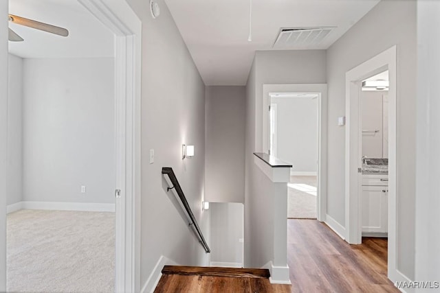 staircase featuring ceiling fan and wood-type flooring