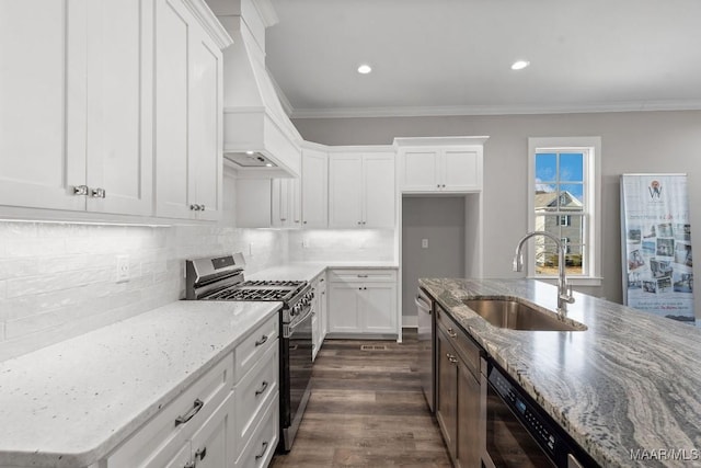 kitchen with sink, white cabinetry, stainless steel appliances, light stone counters, and ornamental molding