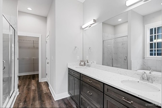 bathroom featuring walk in shower, vanity, and hardwood / wood-style flooring