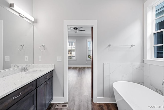 bathroom featuring a bathing tub, wood-type flooring, vanity, and crown molding