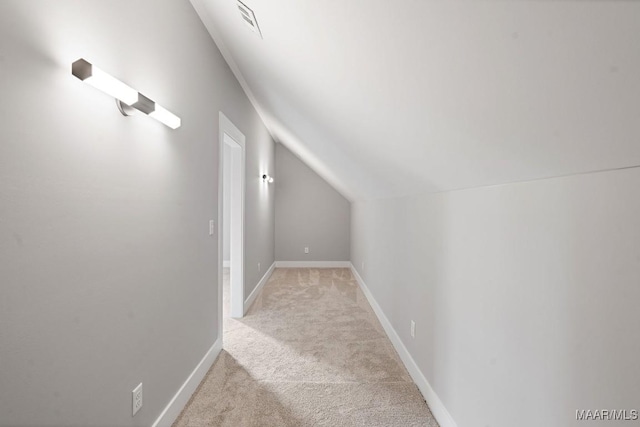 interior space featuring vaulted ceiling and light colored carpet