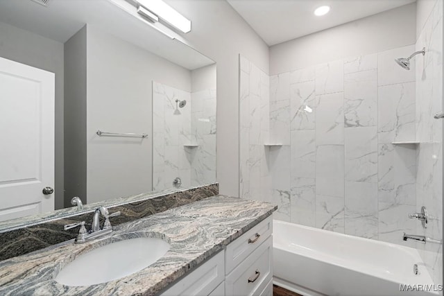 bathroom featuring tiled shower / bath and vanity