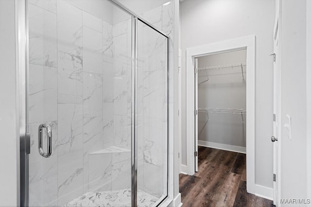 bathroom with hardwood / wood-style floors and a shower with shower door