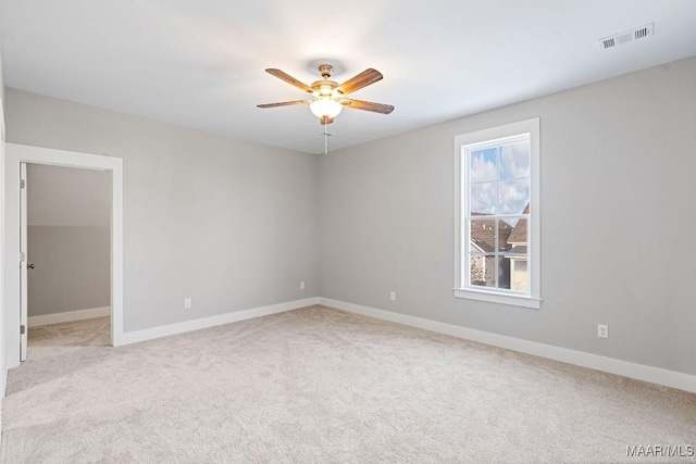 spare room with light colored carpet and ceiling fan