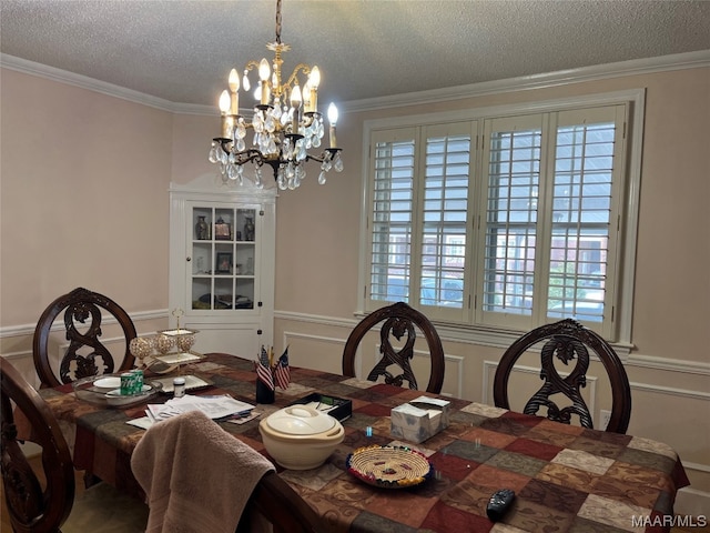 dining space featuring a notable chandelier, a textured ceiling, and ornamental molding