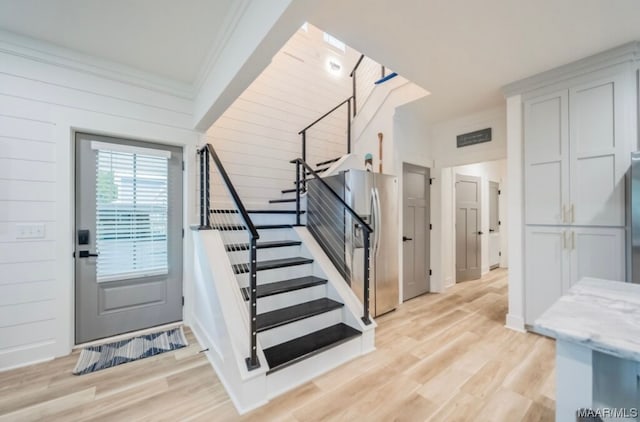 entrance foyer featuring crown molding and light hardwood / wood-style floors