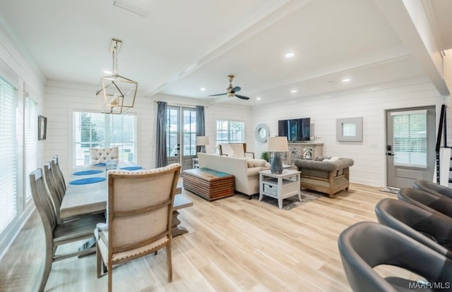 dining room featuring ceiling fan with notable chandelier, beam ceiling, and light hardwood / wood-style floors