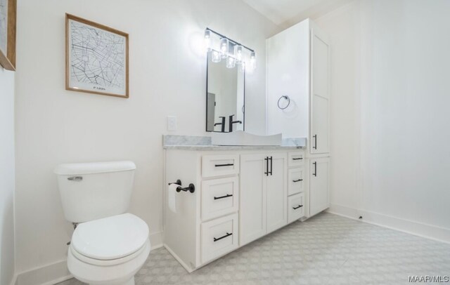 bathroom featuring toilet, tile floors, and vanity