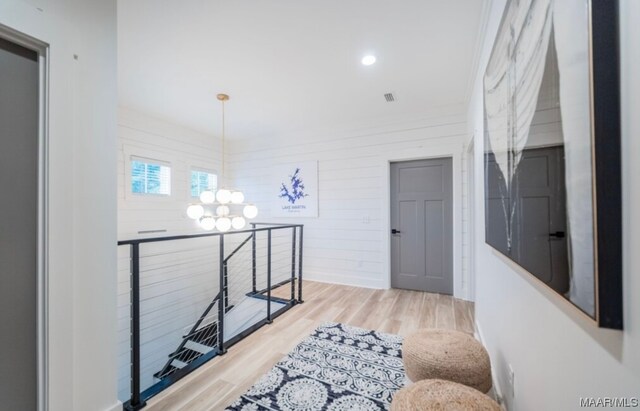 hall featuring a notable chandelier and light hardwood / wood-style flooring