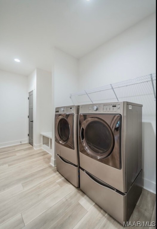 clothes washing area featuring light hardwood / wood-style floors and independent washer and dryer