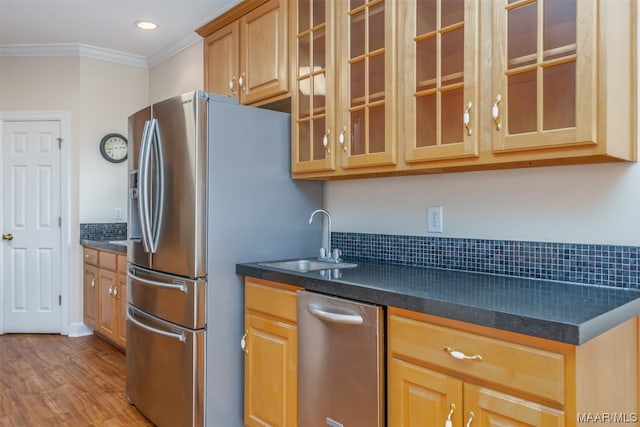 kitchen with sink, light hardwood / wood-style floors, ornamental molding, and appliances with stainless steel finishes