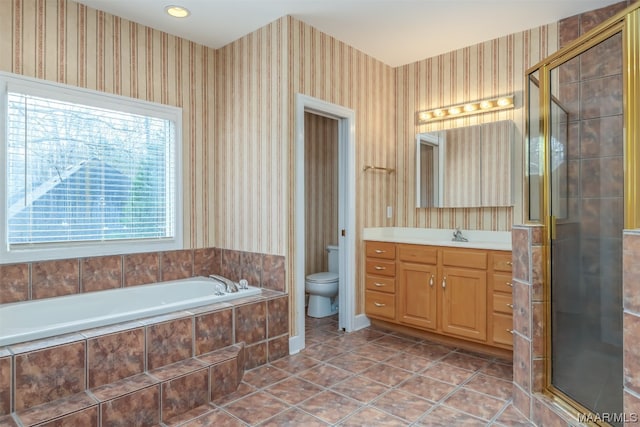 full bathroom with tile floors, separate shower and tub, toilet, and vanity