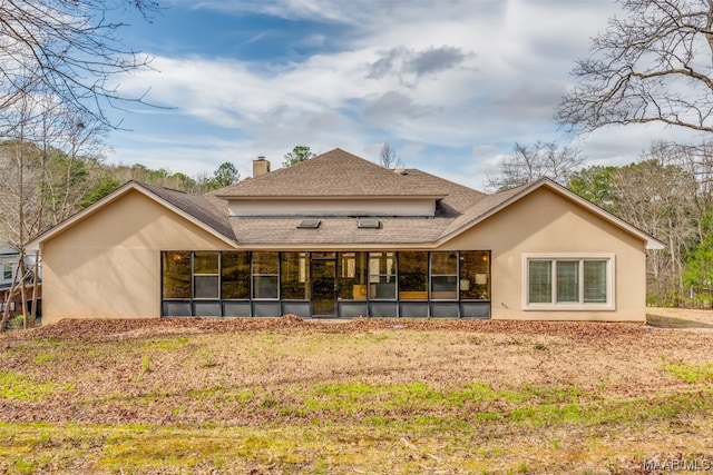 back of house featuring a sunroom and a lawn