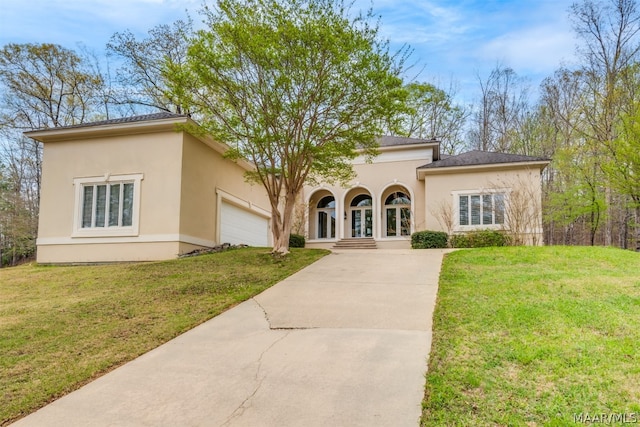 mediterranean / spanish-style house featuring a garage and a front yard