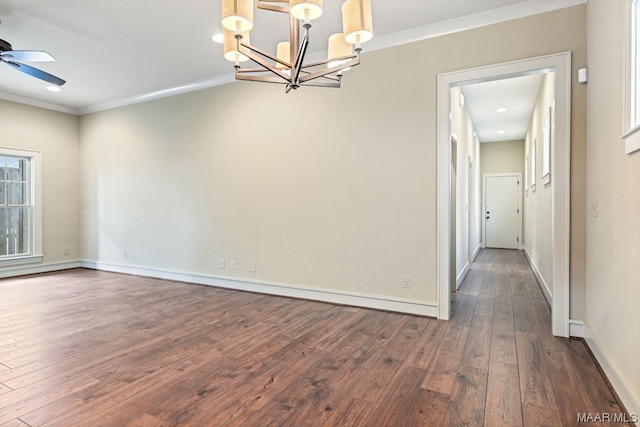 unfurnished room featuring crown molding, dark hardwood / wood-style floors, and ceiling fan with notable chandelier