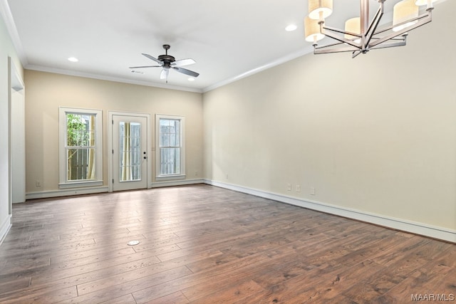 spare room featuring dark hardwood / wood-style floors, ornamental molding, and ceiling fan with notable chandelier