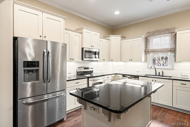 kitchen featuring sink, stainless steel appliances, backsplash, and a kitchen island