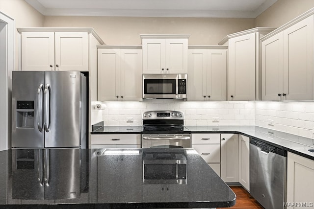 kitchen with white cabinetry, backsplash, stainless steel appliances, dark stone counters, and dark hardwood / wood-style flooring