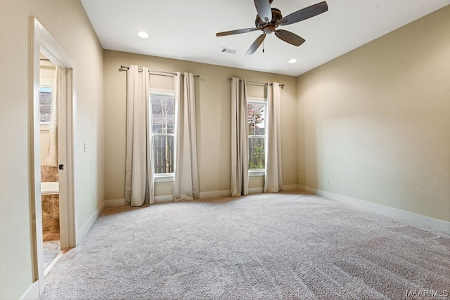 empty room featuring ceiling fan and light colored carpet