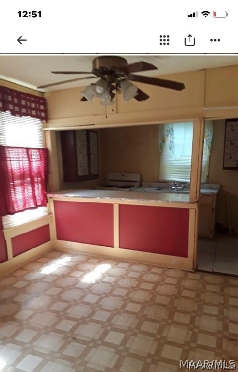 kitchen featuring ceiling fan, stove, and tile flooring