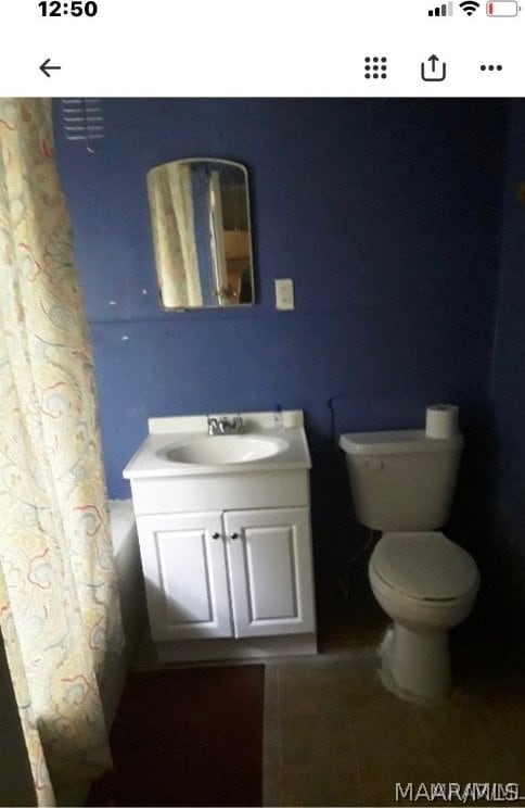 full bathroom with vanity, tile floors, shower / tub combo with curtain, and toilet