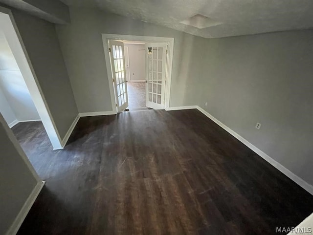 spare room featuring dark wood-type flooring and french doors