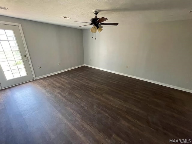 empty room with dark hardwood / wood-style flooring, ceiling fan, and a textured ceiling