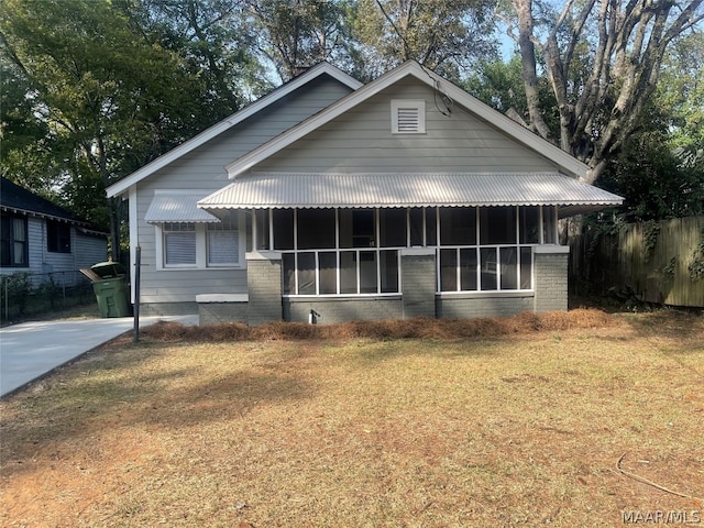 view of front of home with a sunroom and a front lawn