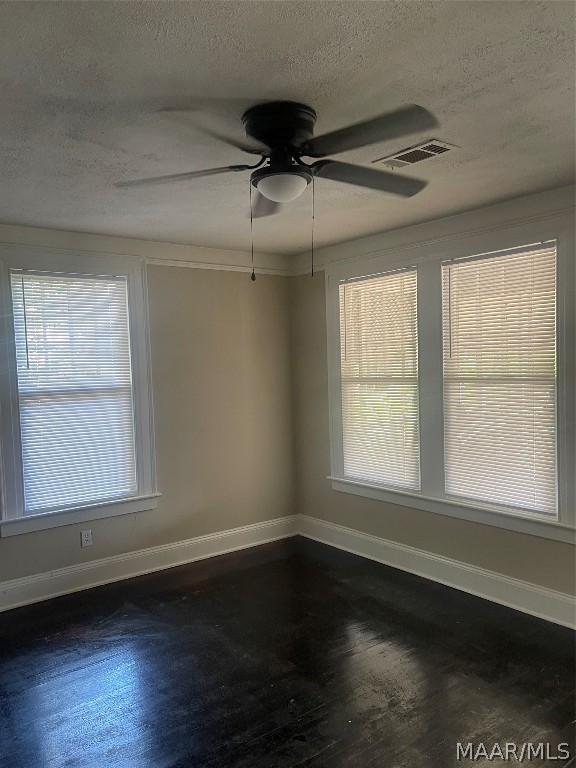 unfurnished room with dark hardwood / wood-style floors, ceiling fan, and a wealth of natural light