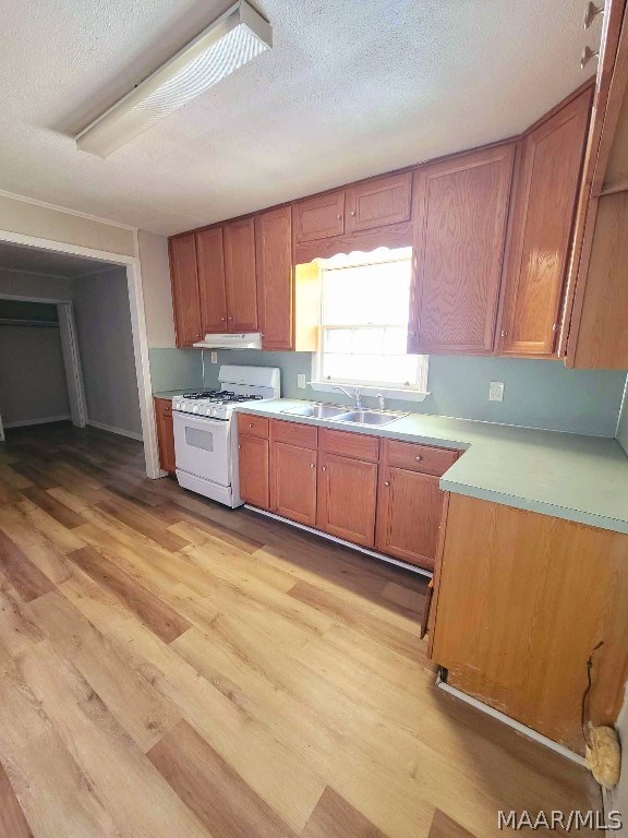 kitchen featuring light hardwood / wood-style floors, white range with gas stovetop, a textured ceiling, and sink