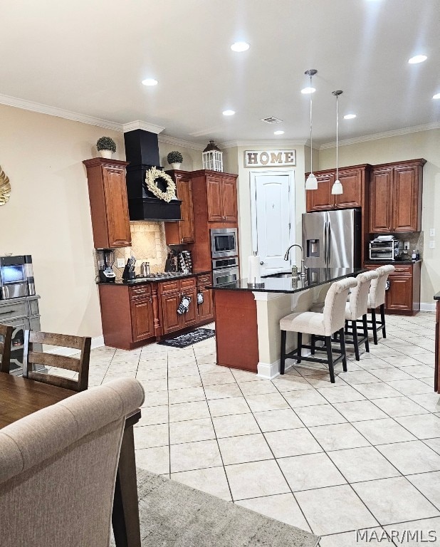 kitchen featuring appliances with stainless steel finishes, hanging light fixtures, backsplash, custom exhaust hood, and crown molding