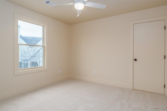 carpeted empty room featuring a wealth of natural light and ceiling fan