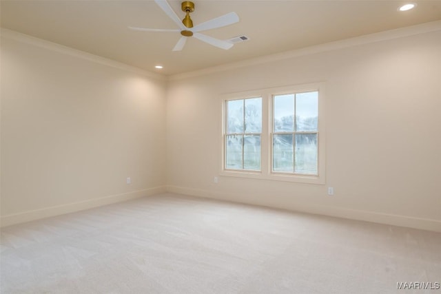 carpeted spare room featuring crown molding and ceiling fan